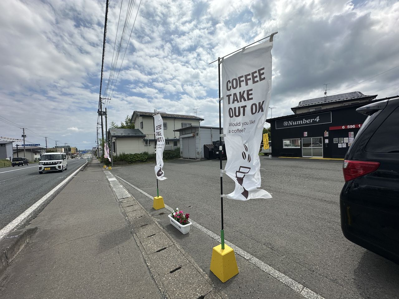道路沿いに白いコーヒーののぼりが立ち、その奥に見えるnumber4の店舗